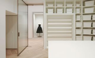Large, bright room with rolls of white fabric and shelving containing white boxes