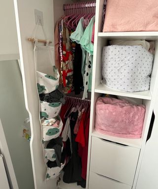 A tension rod being used to hang children's clothes in a small closet