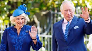 Queen Camilla wears a royal blue dress and matching hat while King Charles wears a blue suit