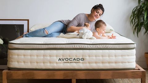 Avocado Green Mattress review image shows a woman and a baby lying on top