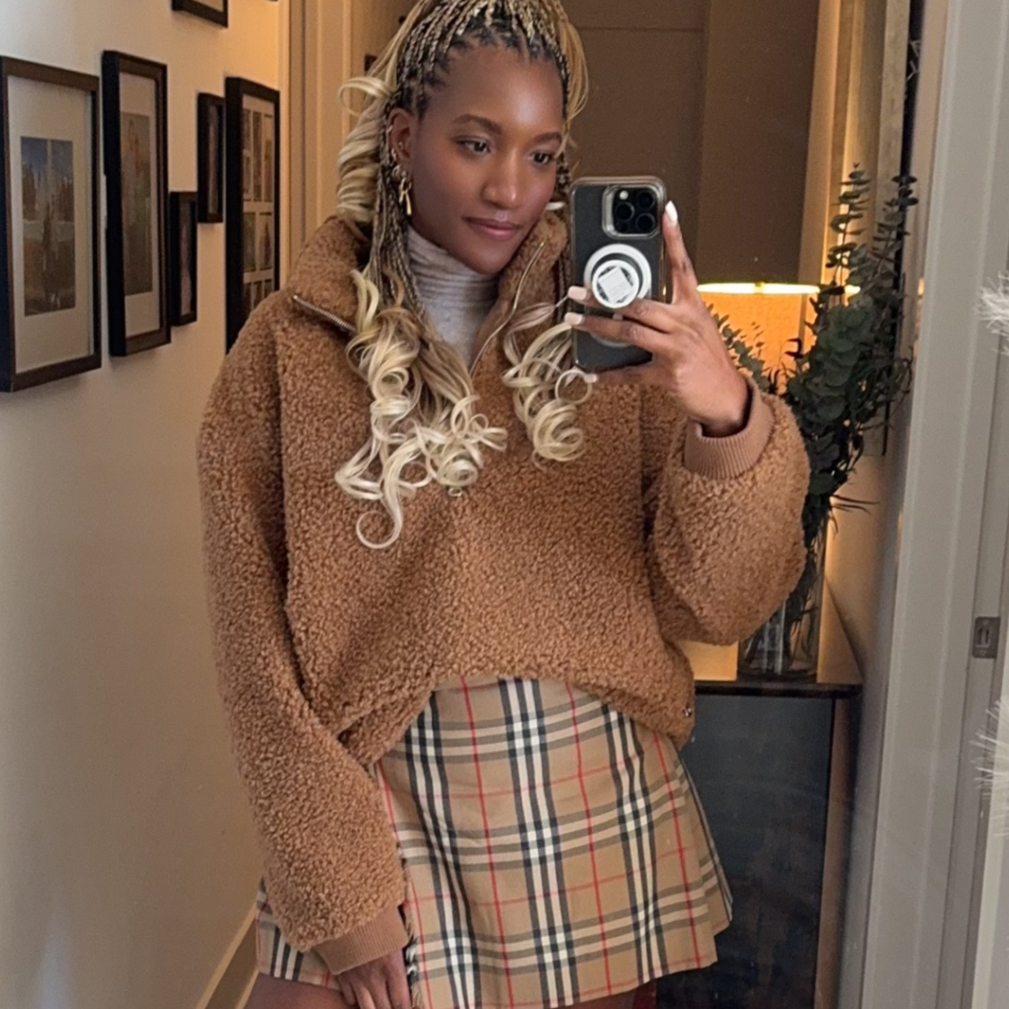Danielle Prescod wearing a sweater and a plaid skirt 