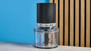 KitchenAid Cordless Top Down Food Chopper photographed in front of a blue background.