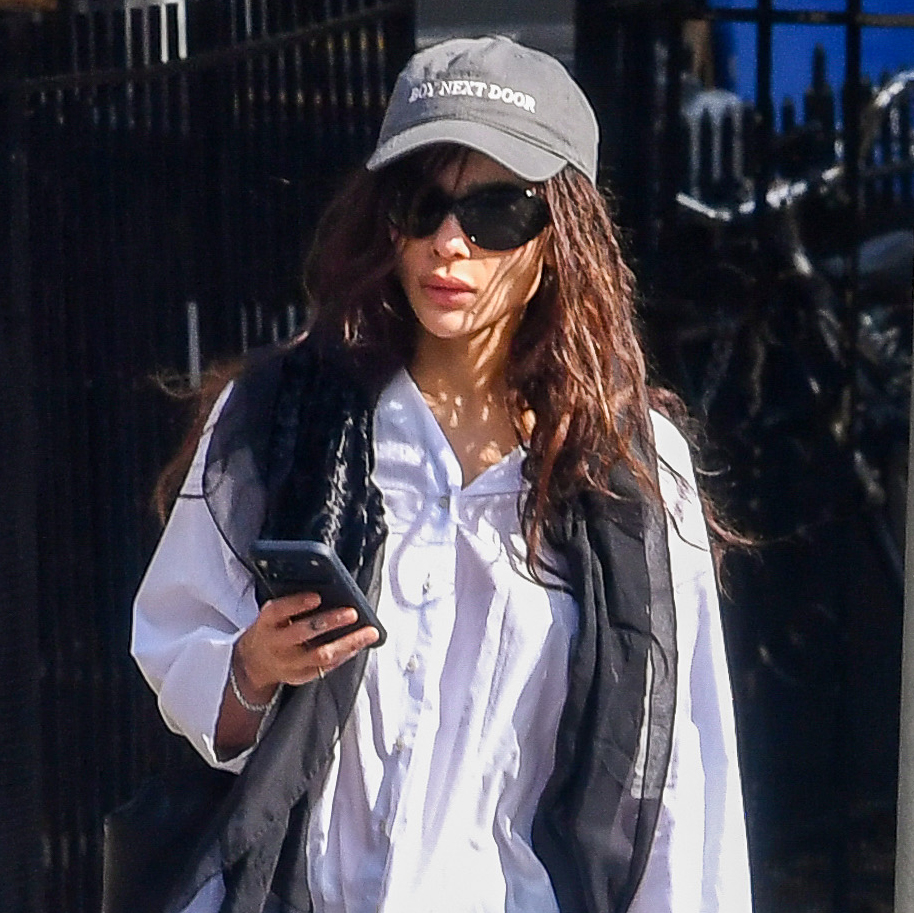 Zo&euml; Kravitz wearing a sheer skinny scarf, white button-down shirt, black pants, and black Adidas Samba sneakers