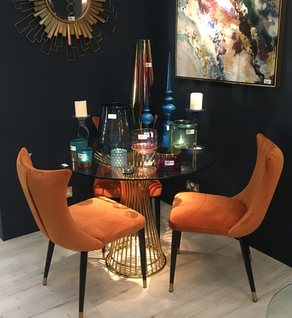 Black wall with painting on wall and table with chairs