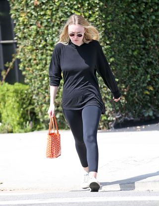 Dakota Fanning carries an orange goyard bag