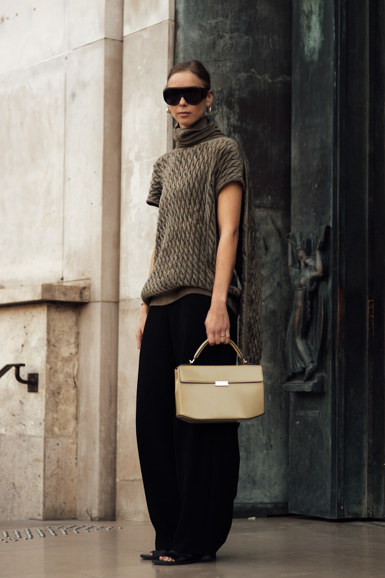 a stylish woman wearing oversize aviator sunglasses during paris fashion week