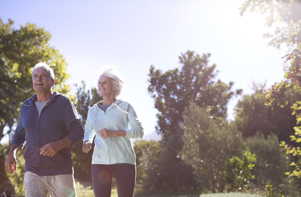 Senior couple running in park