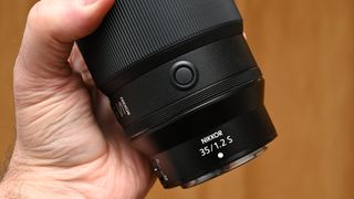 Nikon Z 35mm f/1.2 S product shot with lens held in hand