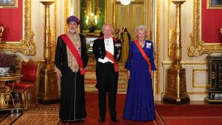 The Sultan of Oman, The King and Queen pose at Windsor Castle in an ornate red-carpeted and gold room