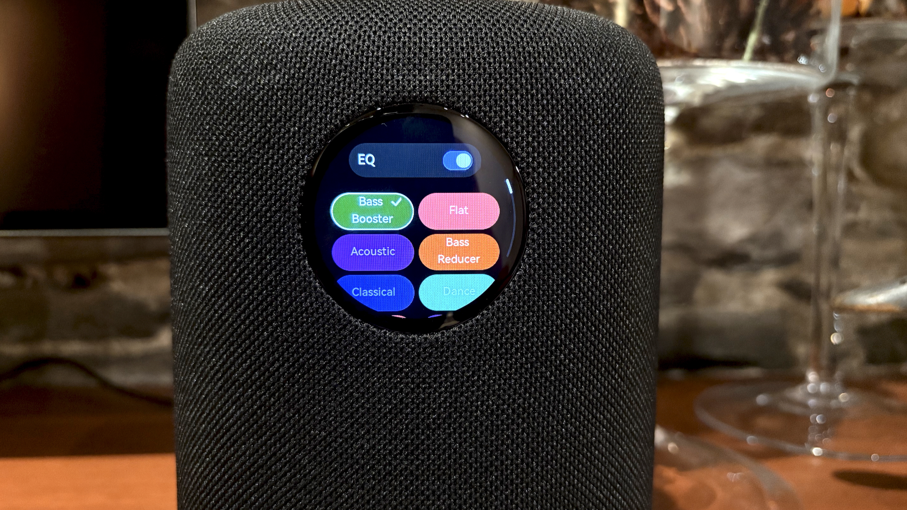 The WiiM Sound, in a home, on a varnished wooden table, showing the illuminated front panel 