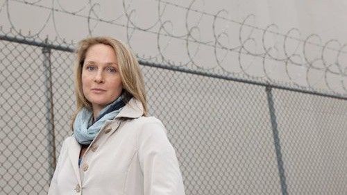 Woman standing next to a prison