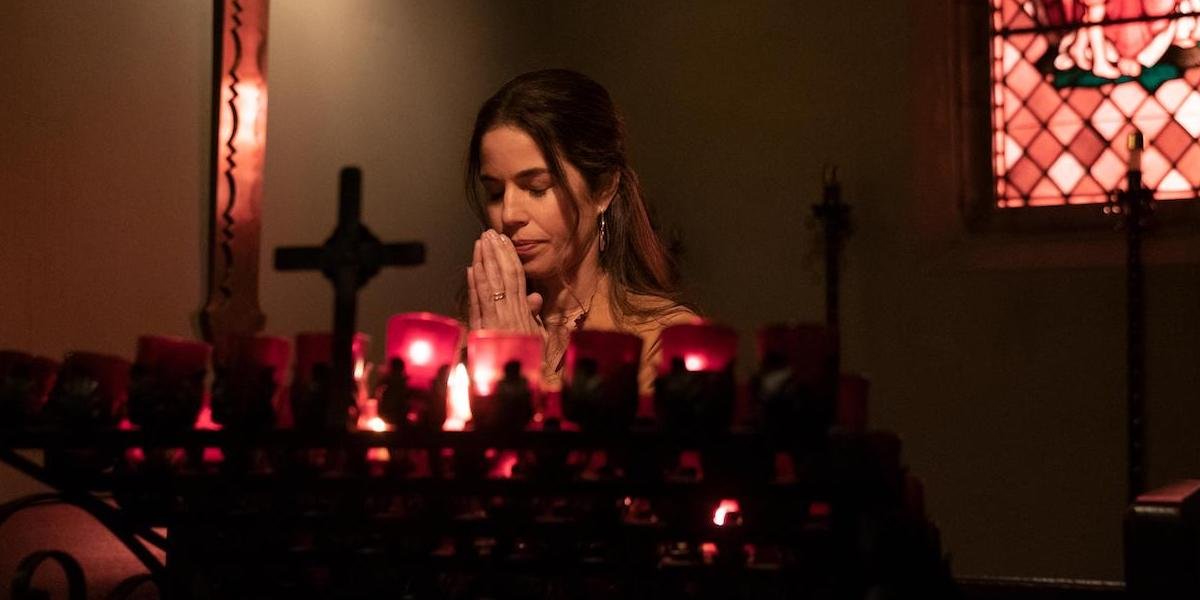 Ana Ortiz praying in a church as Isabel Salazer in Love, Victor