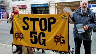 Two protesters holding a banner that says 'Stop 5G'