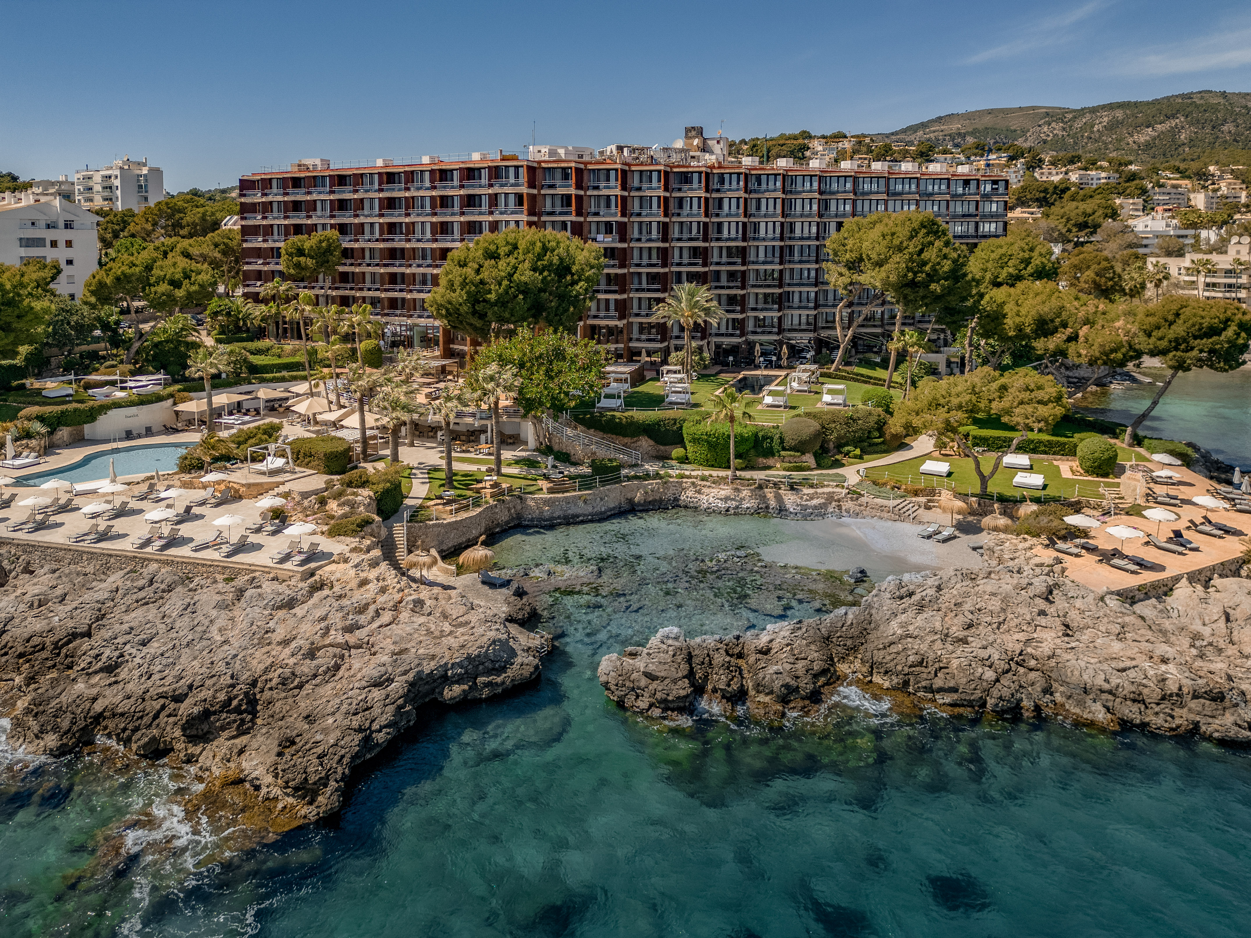 a photo of gran melia de mar hotel from the sea featuring a shot of the beach, pools, and exterior of the hotel