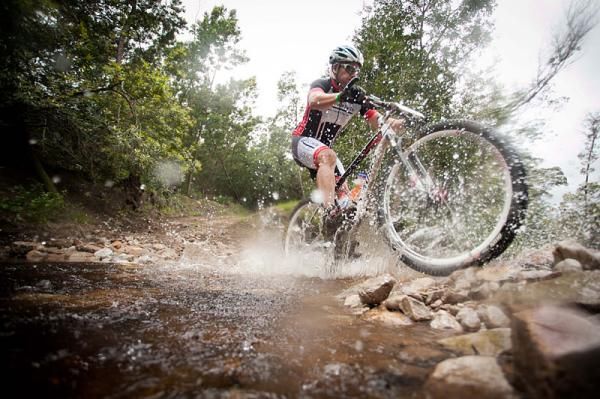 A rider crosses a river during stage 3