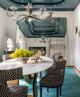 Dining room with turquoise blue rug and Prussian ceiling detail