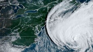 a large white cloud in the shape of a spiral looms off the east coast of the united states