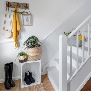 white staircase with potted plant and black long boot