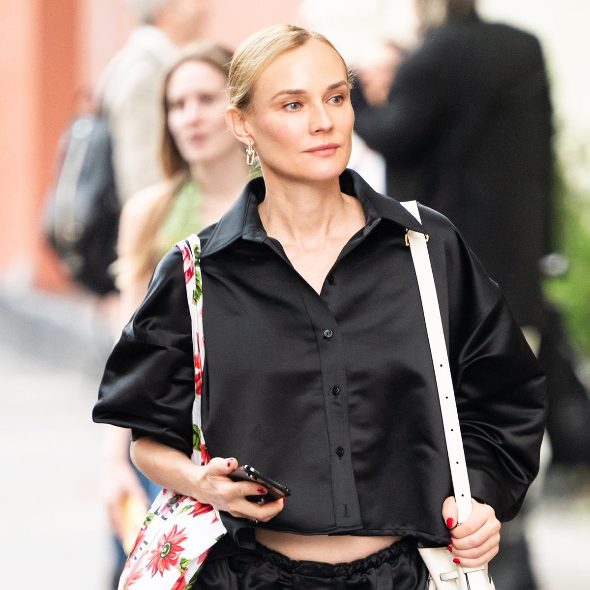 Diane Kruger wearing a black silky button-down shorts, black track shorts, and zebra-print heels in NYC