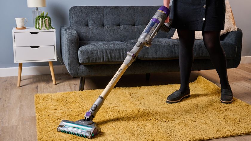 Tester using Shark PowerDetect cordless vacuum in living room