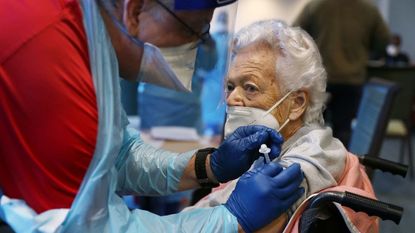 A Florida nursing home resident gets a COVID-19 shot.