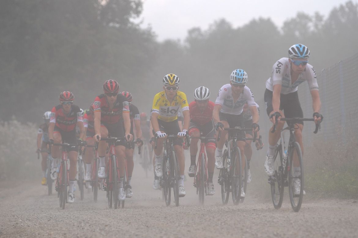 Michal Kwiatkowski (Team Sky) in yellow obscured by dust from the gravel road on stage 7