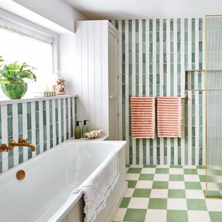 bathroom with green and white floor tiles, shower tiles and bathtub