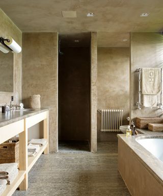 A luxurious pale brown stone bathroom with bath tub.