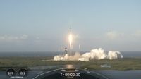 a white and black rocket launches into a blue sky