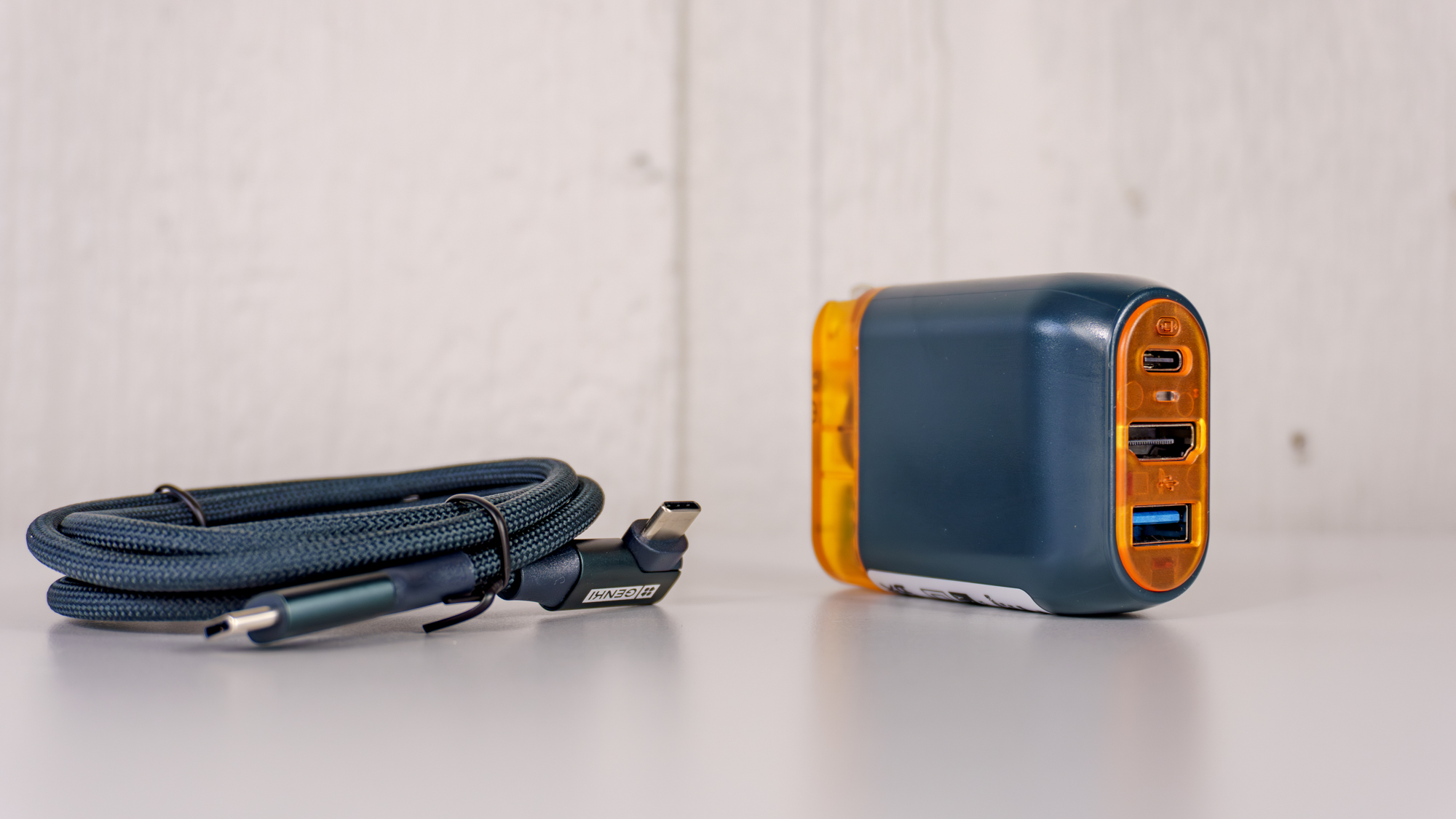 The Genki Covert Dock 3 on a table with its included braided USB-C to USB-C cable