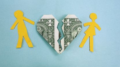 Paper doll cut-out couple with a broken heart made out of a dollar bill between them