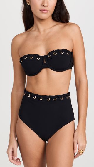 seorang model mengenakan atasan bikini balconette hitam dengan bawahan bertingkat tinggi yang serasi