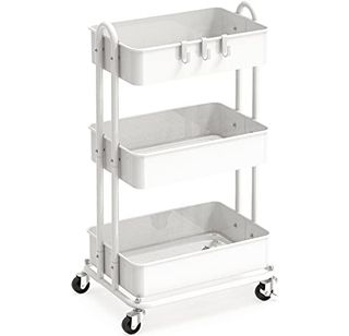 A white metal three tier rolling cart with four black wheels and three hookso on the top basket