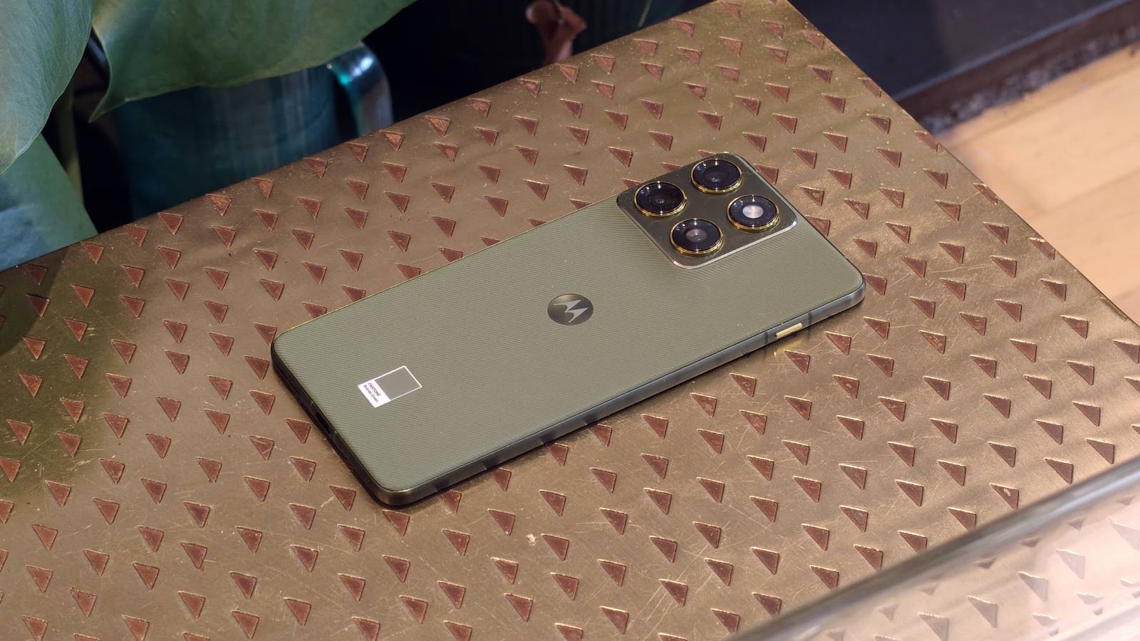 The Motorola Edge 70 face-down on a brown table.