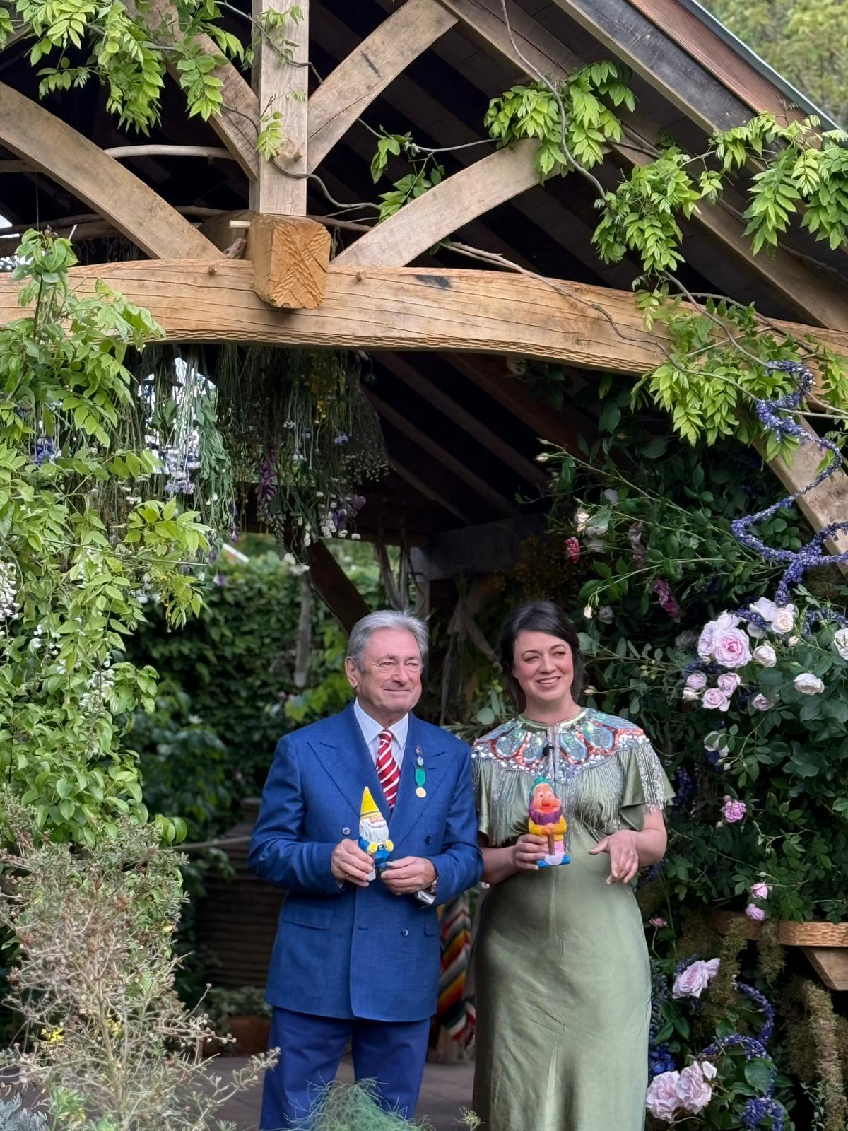 Alan Titchmarsh and Frances Tophill are holding a gnome each. They look delighted