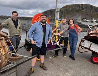 Banjo and the team on Easdale surrounded by wheelbarrows full of furniture and accessories: from left to right, Tom Reade, Banjo Beale, Eoghann MacLean and Lisa McKenna