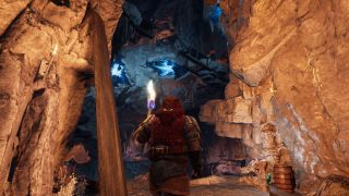 Return to Moria - a dwarf holds a torch in an underground cave