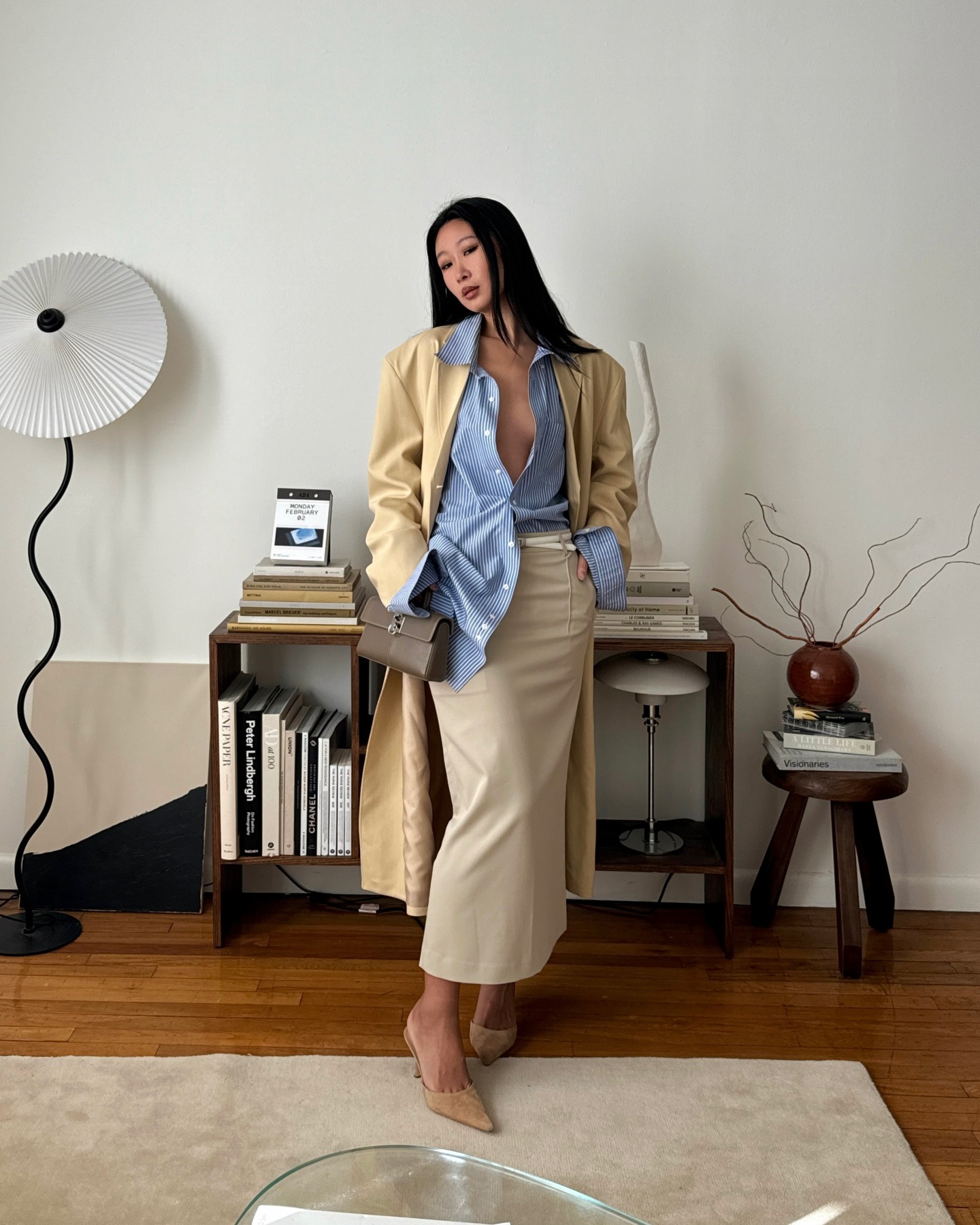 Woman wears yellow coat, blue shirt, beige skirt