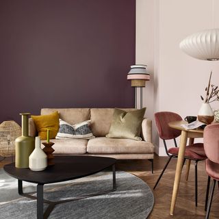 living room with purple and white wall light brown sofa with cushions and wooden floor