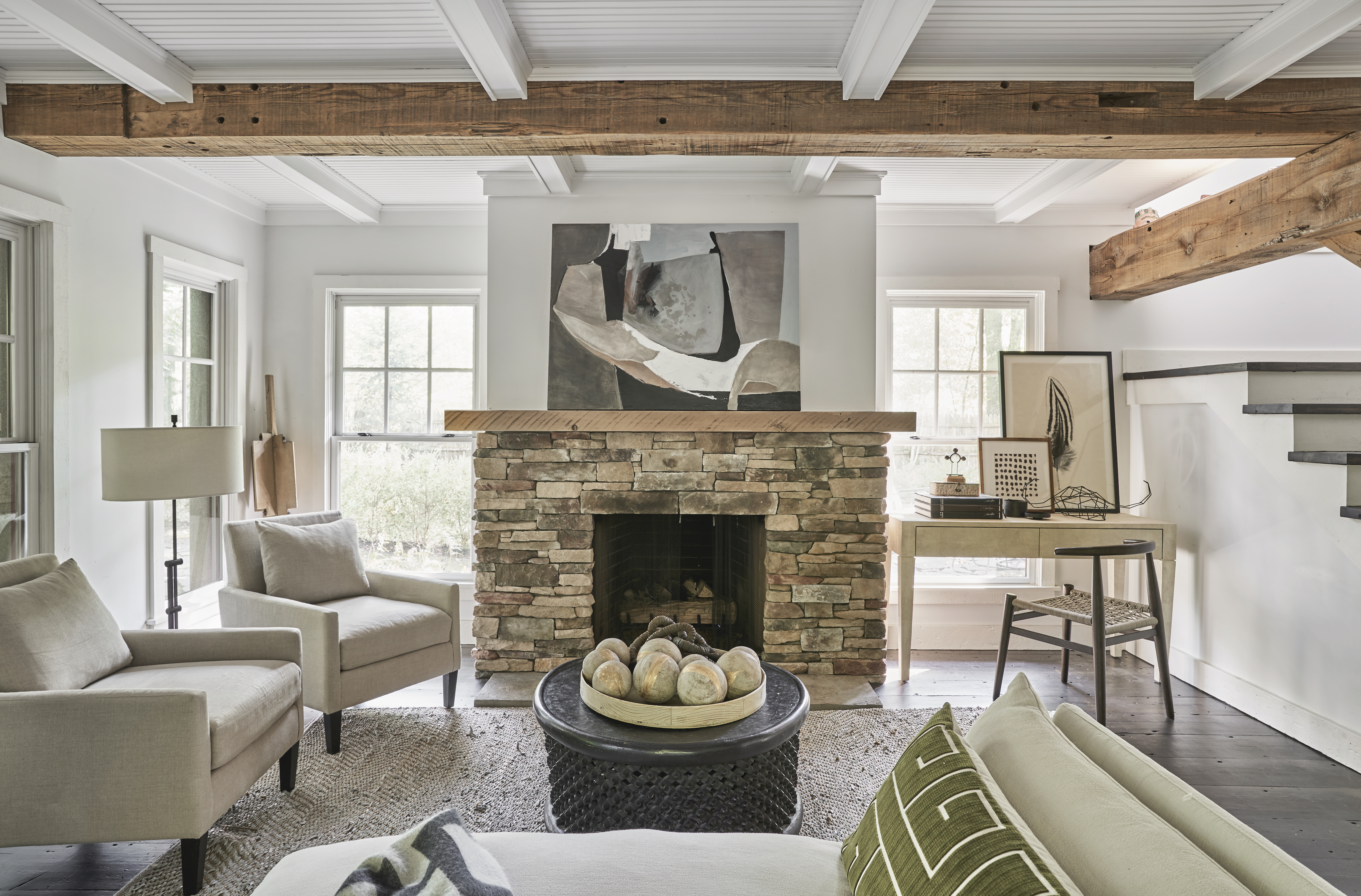 living room with fireplace with artwork above, sofa and armchairs