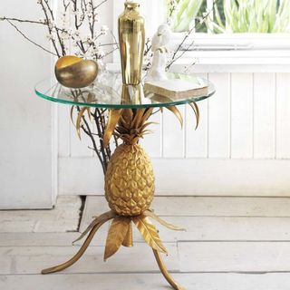 Golden Pineapple Table on a white wooden floor