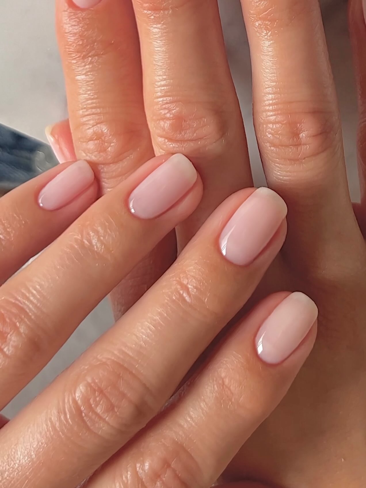 A close-up shot of a natural-looking manicure