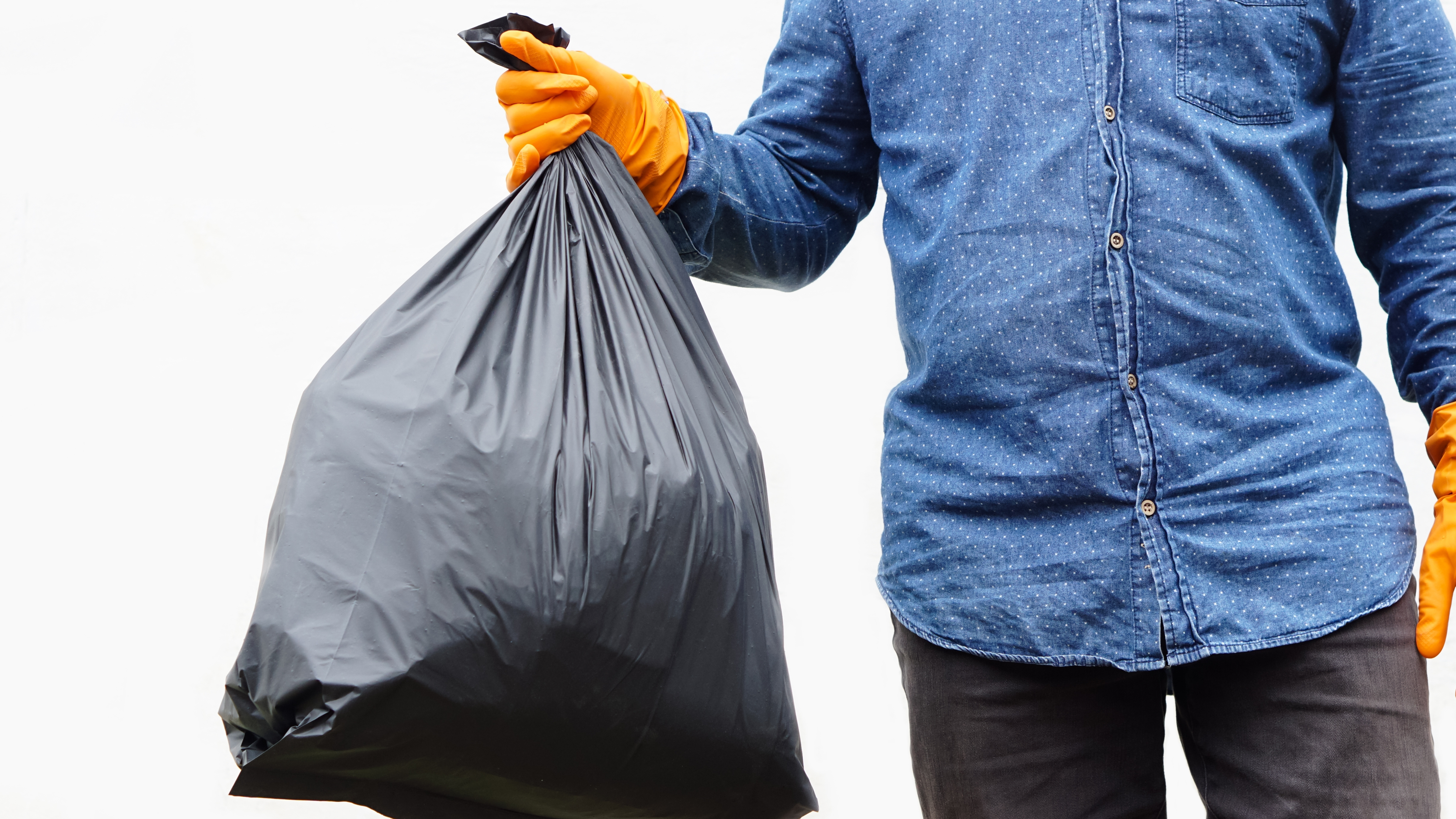 Man carrying a black trash bag