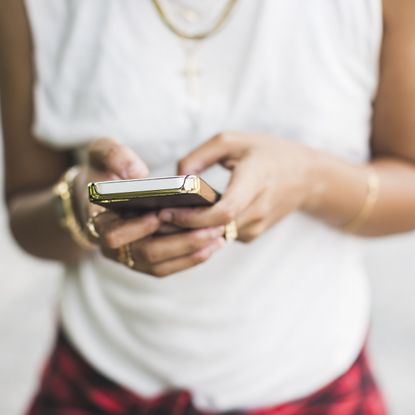 Cropped shot of young woman texting on smartphone