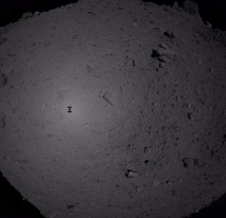 Japan&#039;s Hayabusa2 spacecraft captured this photo during its sample-grabbing descent toward the asteroid Ryugu on Feb. 21, 2019. The probe&#039;s shadow is visible on the space rock&#039;s surface.