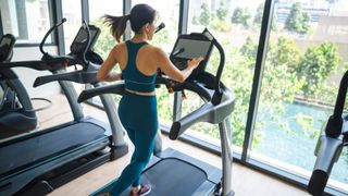 Woman running on a treadmill looking out across open window