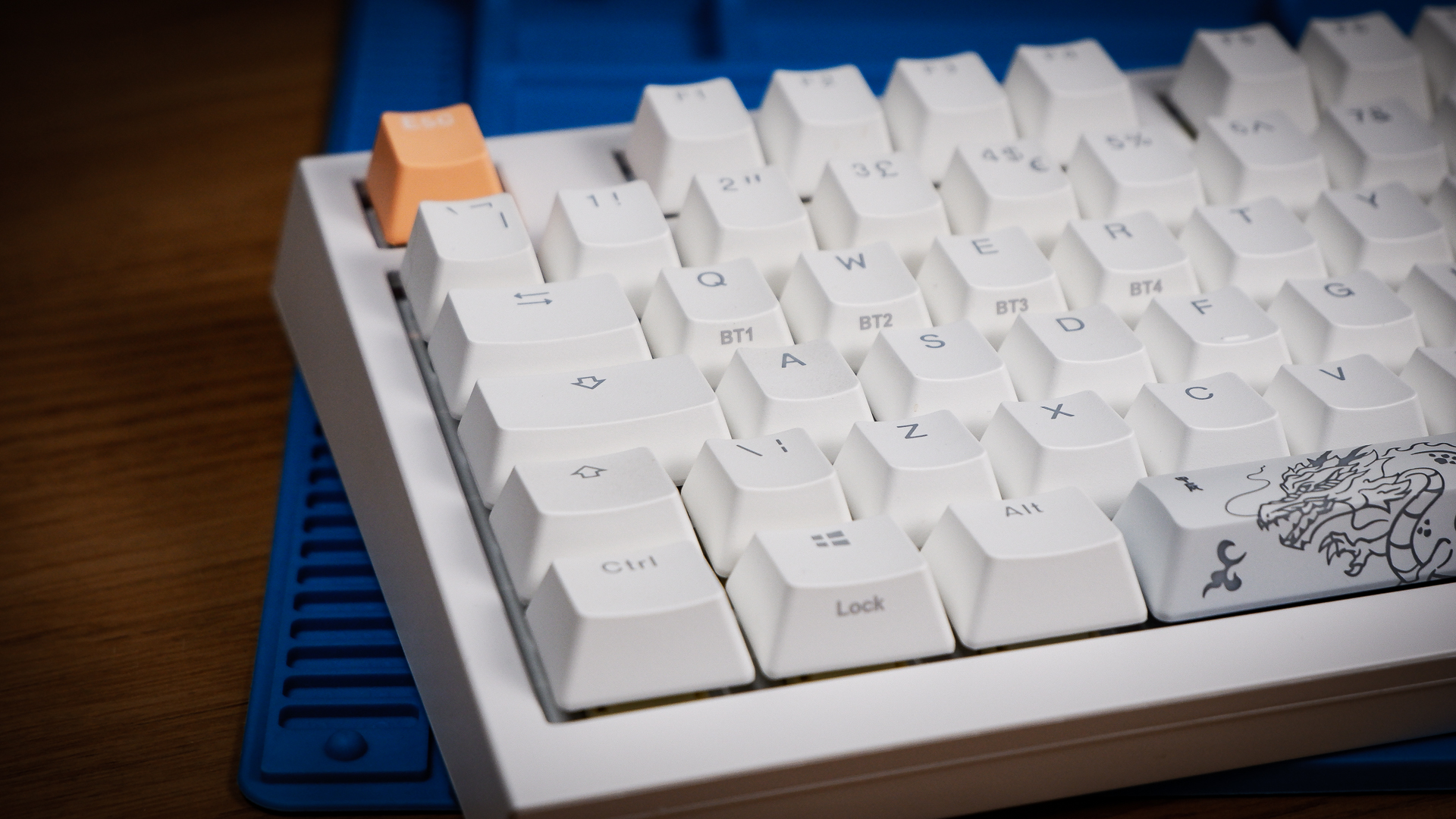 The Ducky One X induction gaming keyboard on a blue mat on a desk, with keycaps removed.