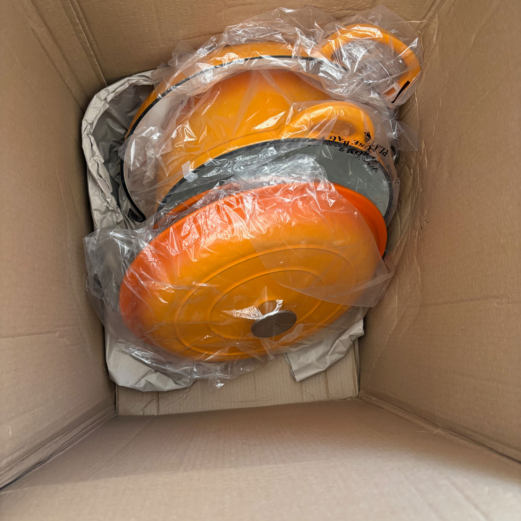 Orange cast iron cookware in a box