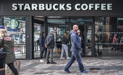 Customers queue to enter Starbucks Coffee Shop.