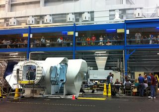 The 2012 RATS team prepares for mission start in JSC's Building 9, with the prototype second-generation space exploration vehicle on the left and spectators in the overhead "catwalk."